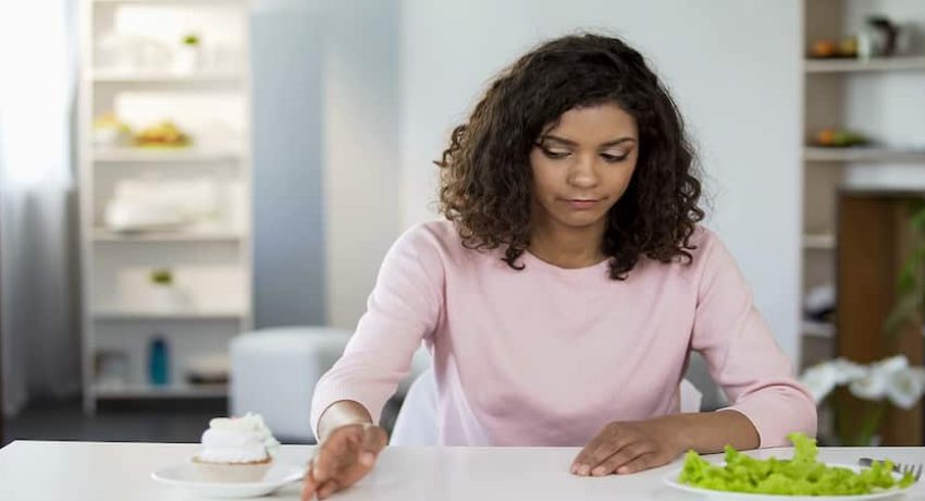 Attractive woman sadly choosing salad over cake, weight control, diet nutrition